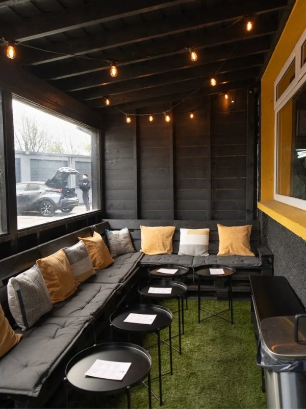 HQ Brew outdoor lounge with string lights and gold cushions